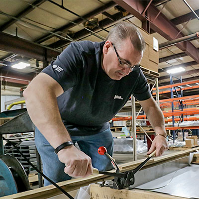 Employee Combining Straps For Shipment